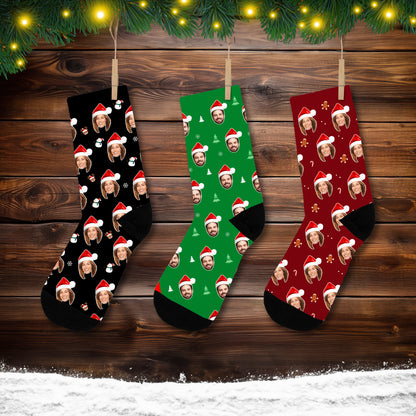 Custom holiday socks displaying a repeated face pattern wearing a Santa hat, perfect for Christmas gifts. The design includes holiday symbols like gingerbread cookies and candy canes on a black background.